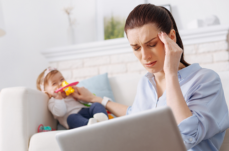 Woman with child in everyday life experiences migraine on one side of the head